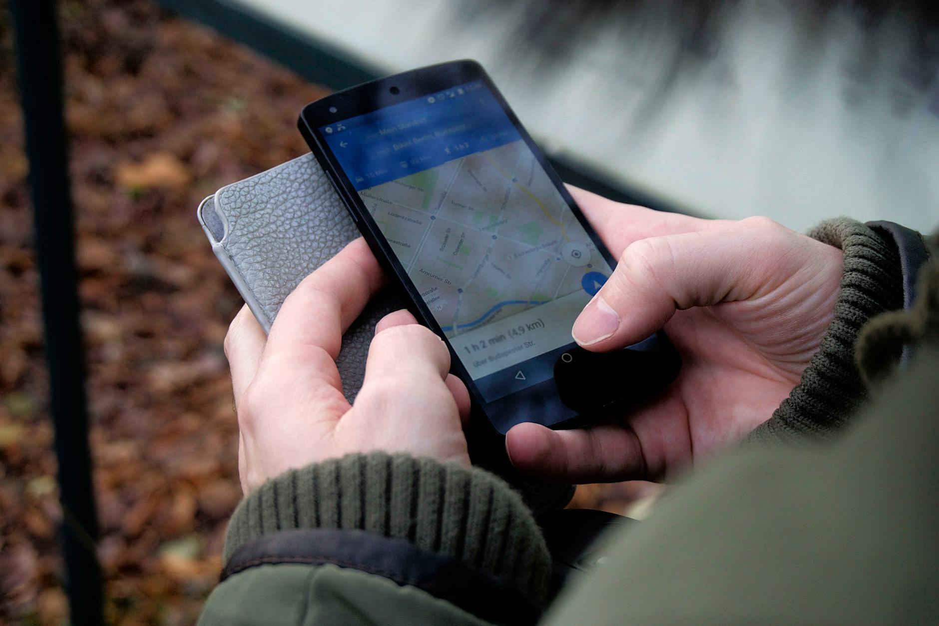 Dłonie trzymające smartfon z mapą nadajników na zewnątrz