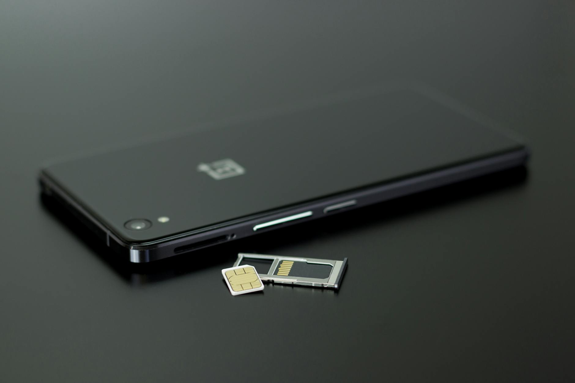 Smartfon z kartą SIM i kartą pamięci włożonymi obok obudowy