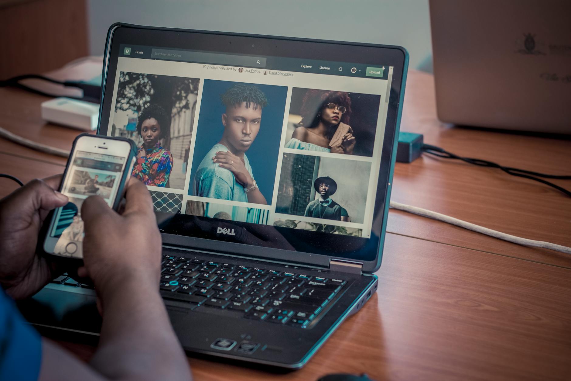 Osoba przegląda zdjęcia na laptopie Dell i smartfonie w domu