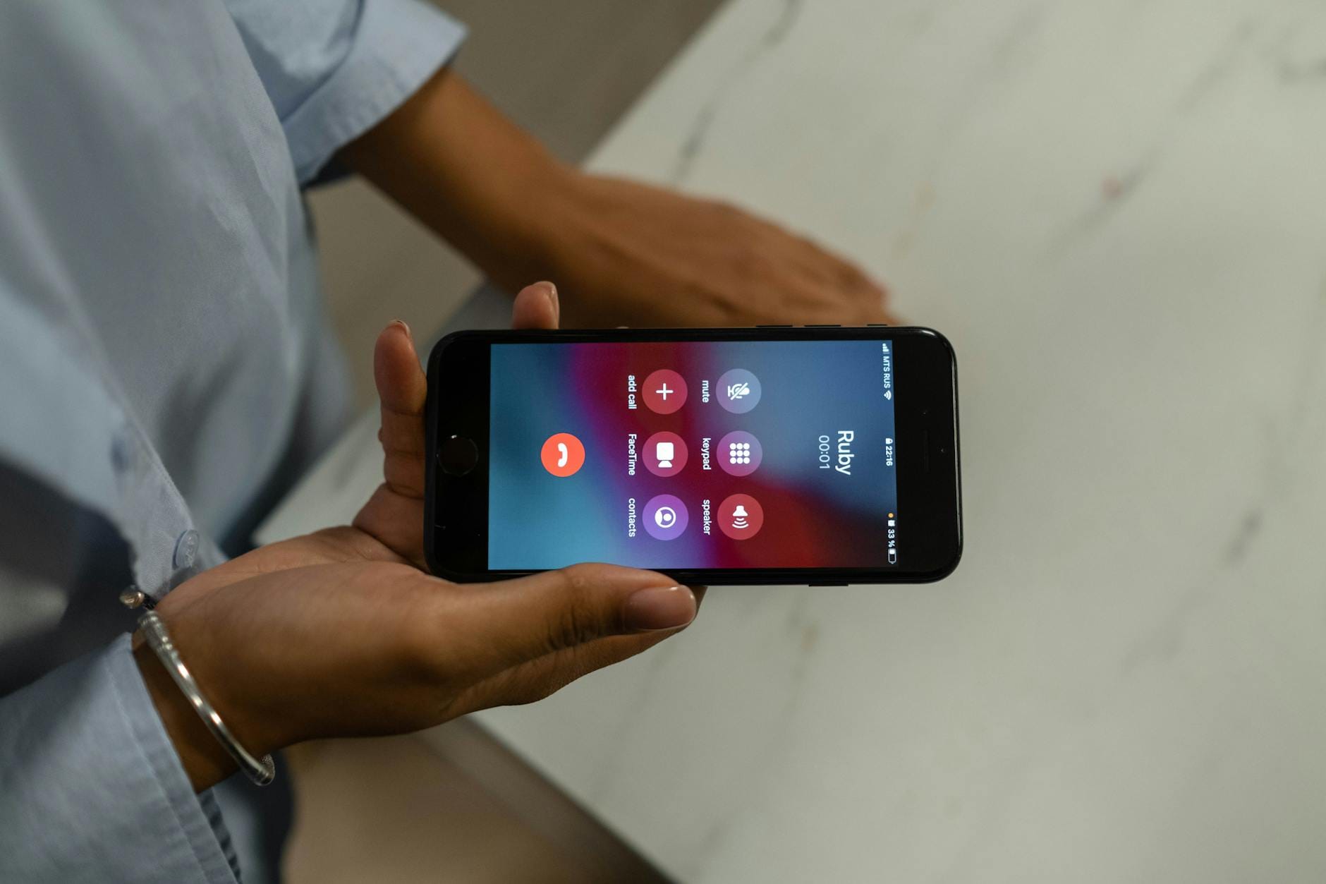 Zbliżenie dłoni trzymającej smartfon z ekranem nadchodzącego połączenia