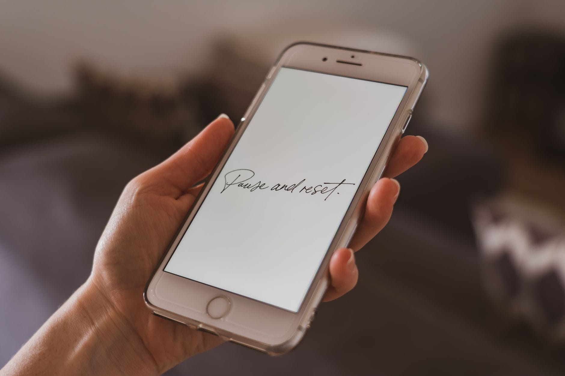 Jak przywrócić domyślne ustawienia telefonu bez utraty zdjęć, kontaktów i ważnych dokumentów Dłoń trzymająca smartfon z motywującym cytatem na ekranie