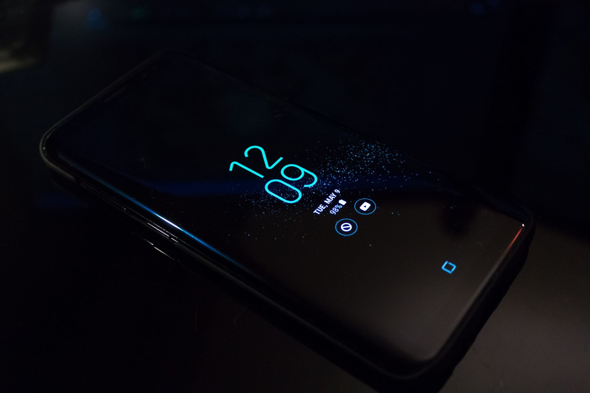 Smartfon w ciemności z zegarem i powiadomieniami na ekranie