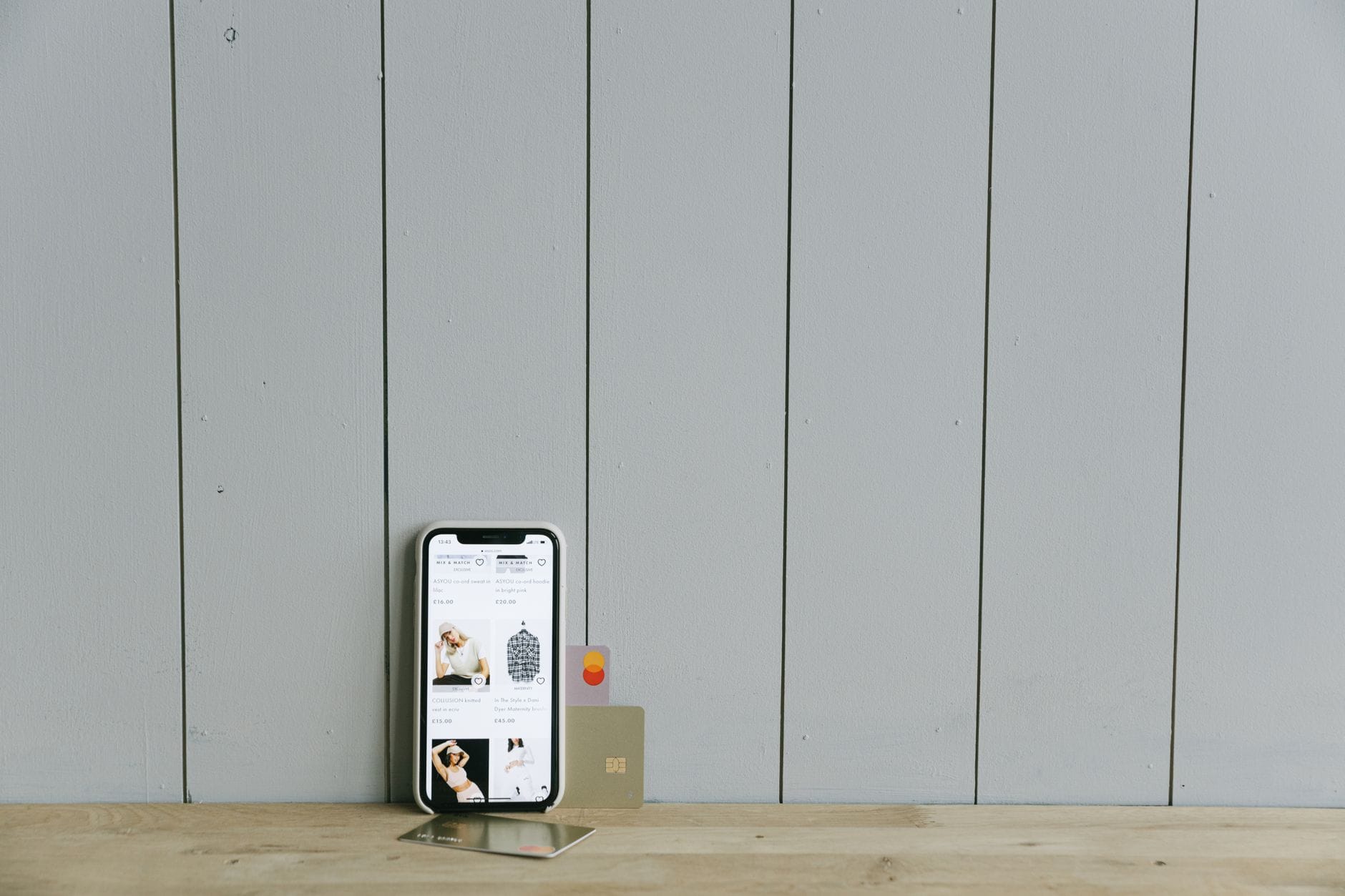 Smartfon z otwartym sklepem internetowym i kartą płatniczą na stole