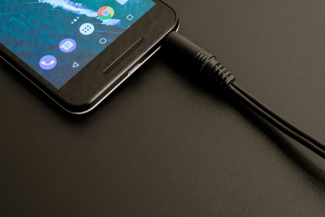 Smartfon podłączony do ładowania z widocznym interfejsem na ekranie