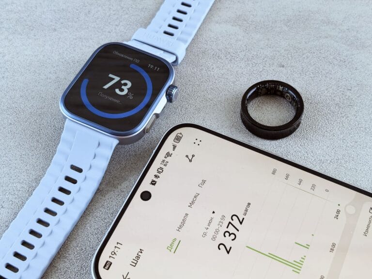 Smartwatch z danymi fitness, smartfon i pierścień zdrowotny na szarym tle