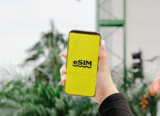 Telefon z wyświetloną kartą eSIM trzymany